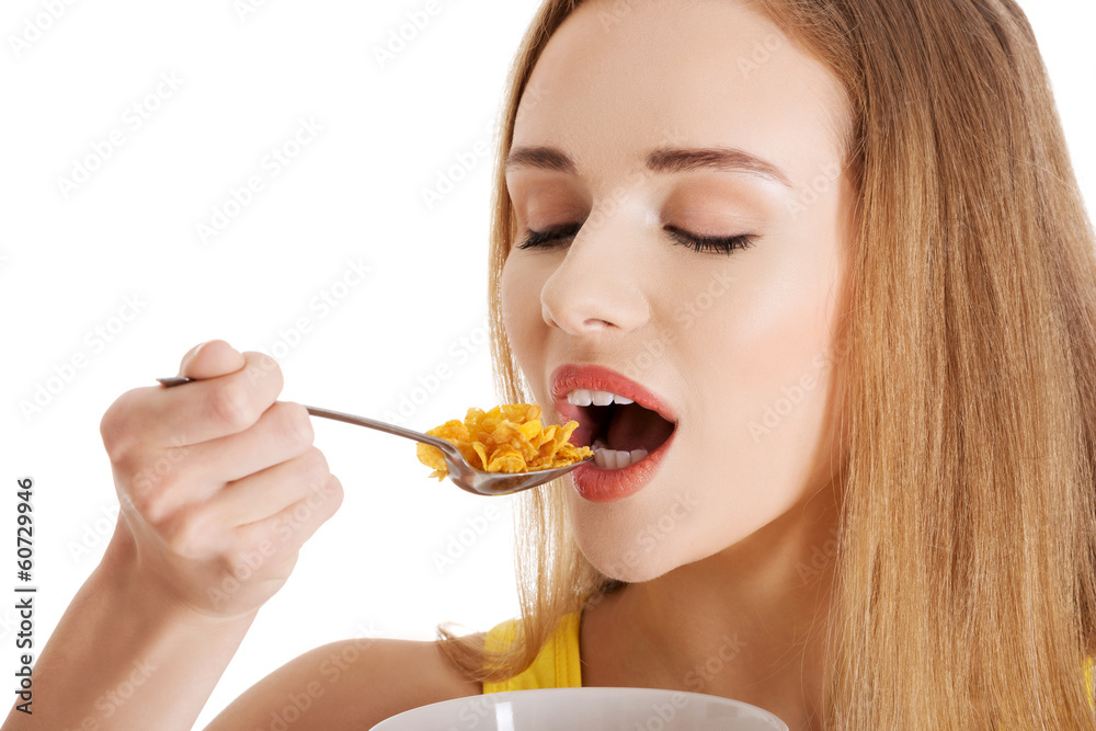 Beautiful caucasian slim woman eating corn flakes. Beautiful caucasian slim woman eating corn flakes.