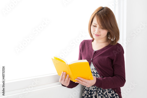 窓辺で本を読む女性