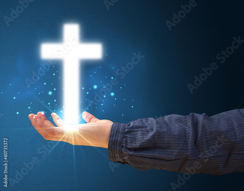 Glowing cross in the hand of a woman