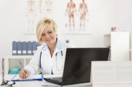 Blonde beautiful female doctor working in her office