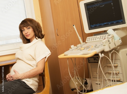 Young pregnant woman in ultrasound examination cabinet 