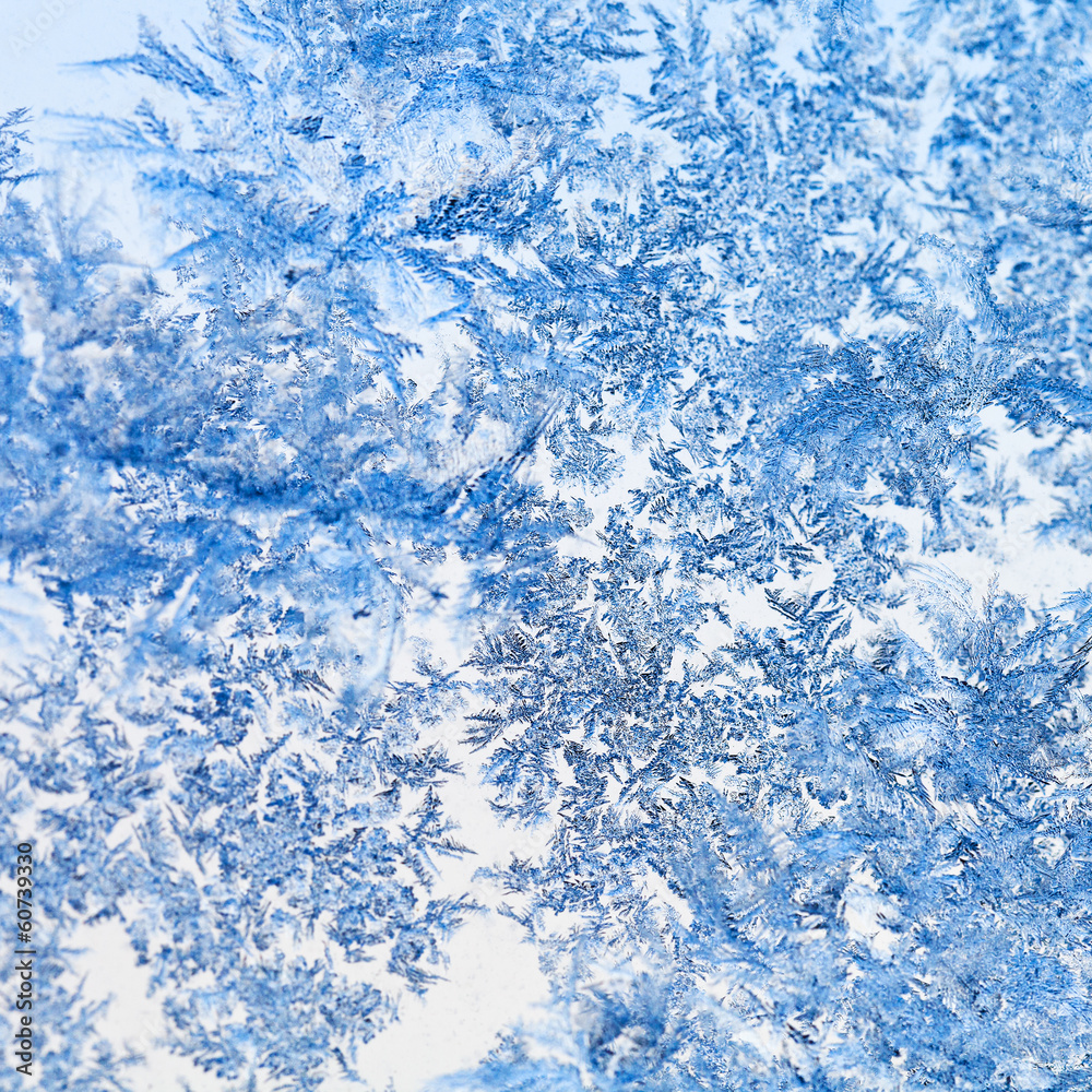 snowflakes and frost pattern on glass close up