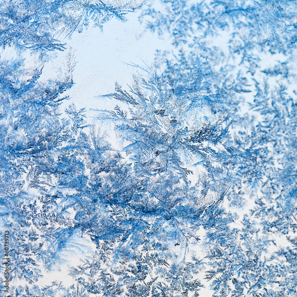 Fototapeta premium snowflakes and frost pattern on glass close up