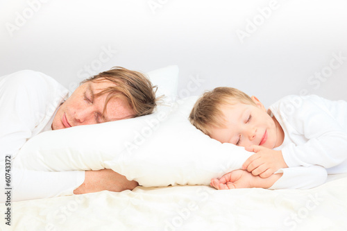 father and son sleep in bed