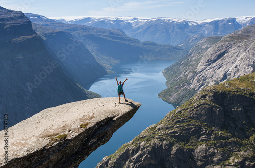 girl with backpack on trolltunga in norway photo