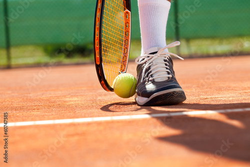 Leg with ball and tennis racket © luckybusiness