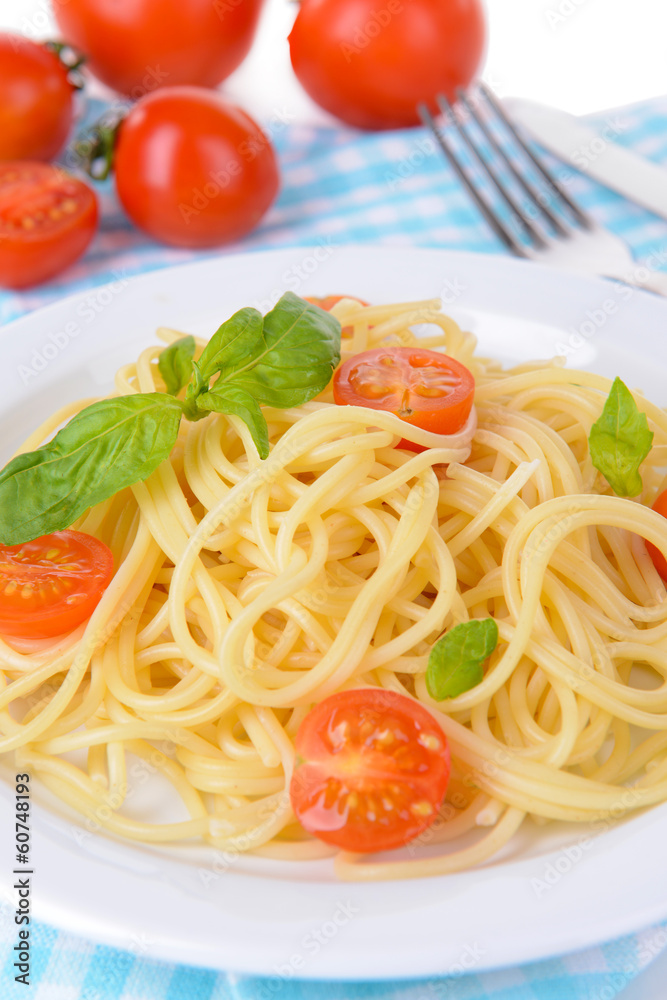 Delicious spaghetti with tomatoes on plate on table close-up