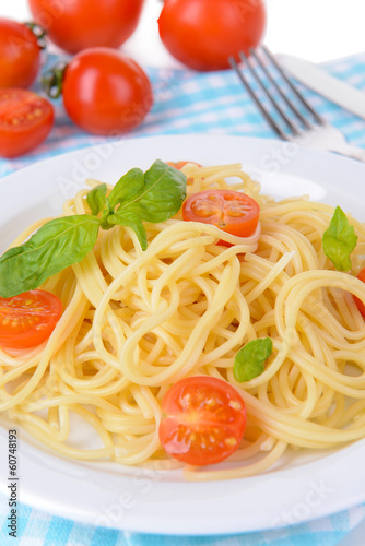 Delicious spaghetti with tomatoes on plate on table close-up