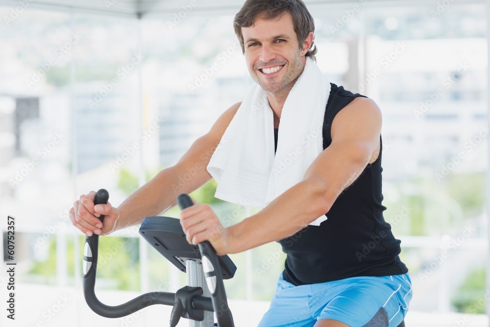 Smiling man working out at spinning class in bright gym Smiling man working out at spinning class in bright gym
