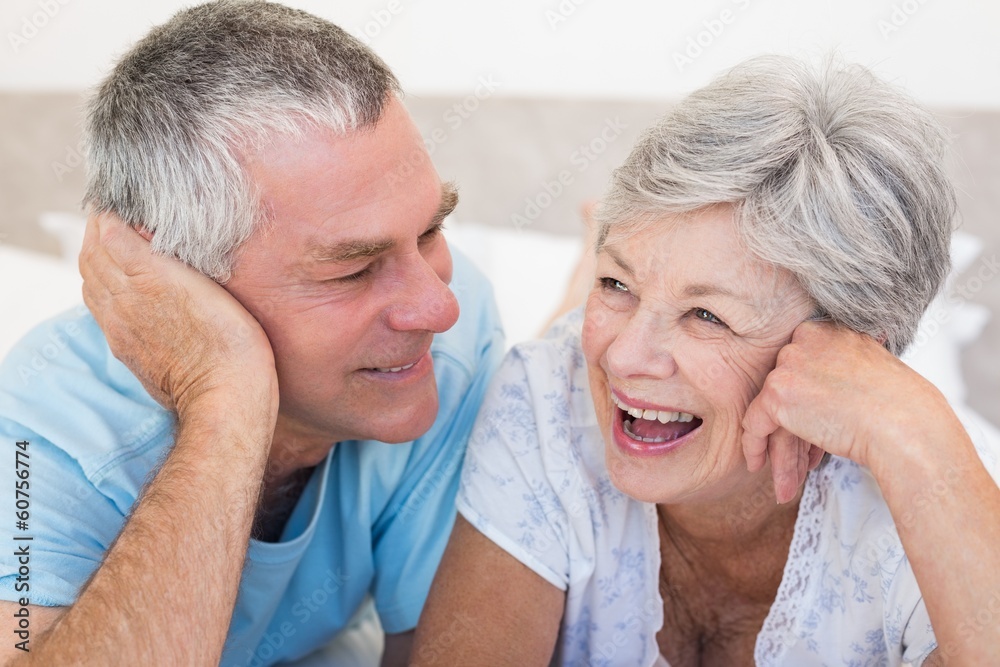Happy senior couple lying on bed Happy senior couple lying on bed