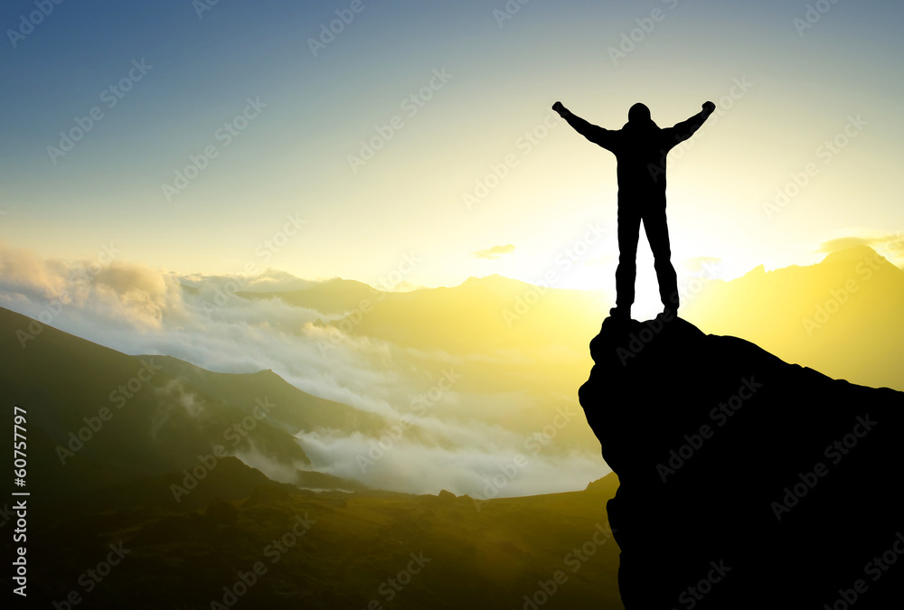 Silhouette of a winner on the mountain top. Active life concept
