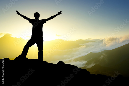 Silhouette of a winner on the mountain top. Active life concept