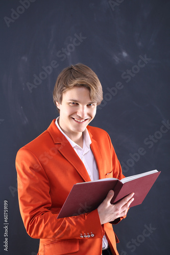 Uśmiechniety młody nauczyciel trzyma tabelę wyników