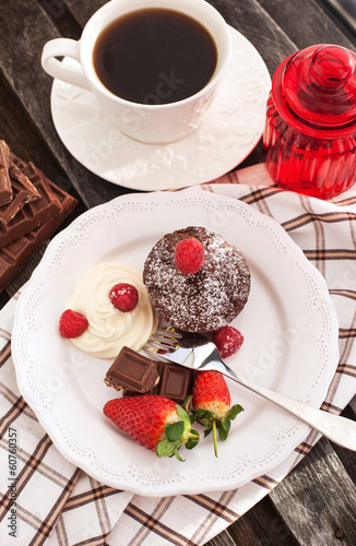 Chocolate muffin served with cream and fresh berris photo