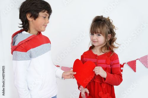 Boy giving heart to his sweetheart but she is not happy photo