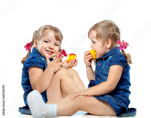 portrait of twin girls eat fruit, abstract background