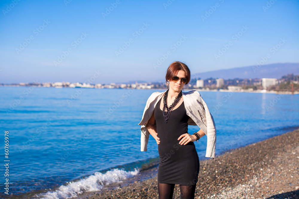 Portrait of Beautiful young woman walking on the beach in winter