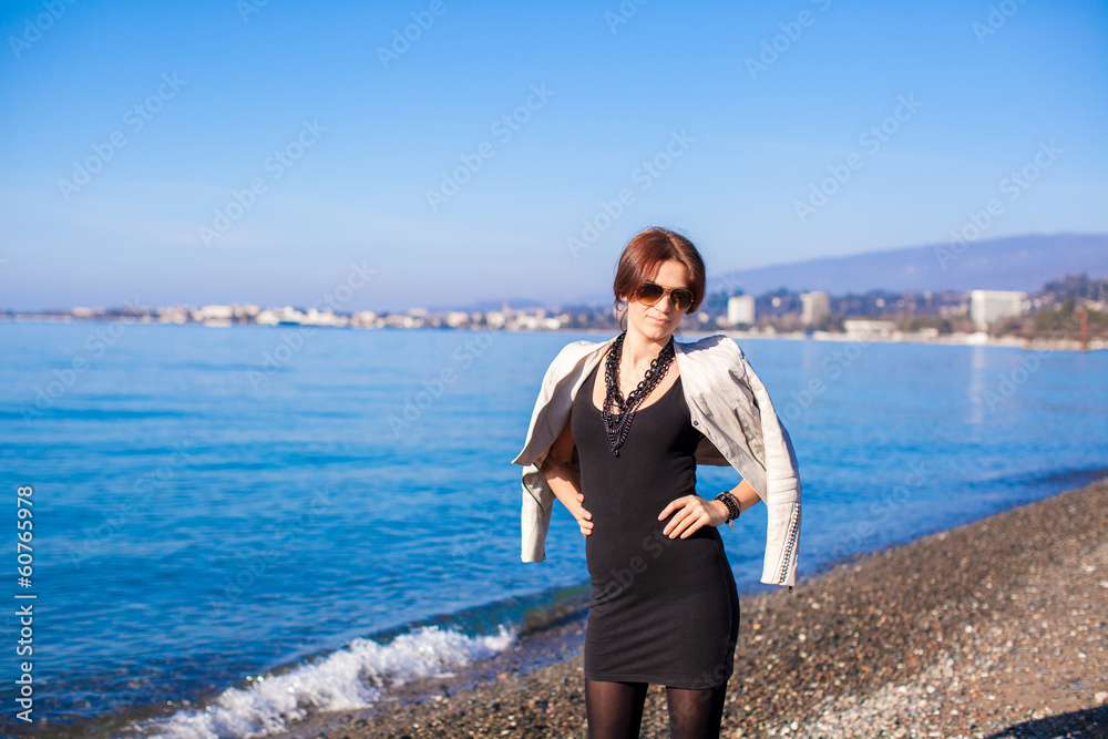 Portrait of Beautiful young woman walking on the beach in winter Portrait of Beautiful young woman walking on the beach in winter