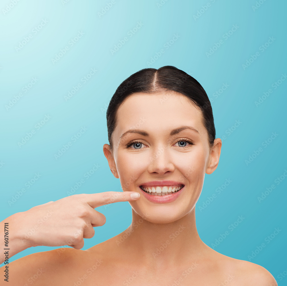 young calm woman pointing to her mouth young calm woman pointing to her mouth