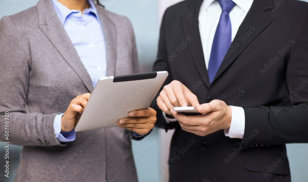 two businesspeople with smartphone and tablet pc two businesspeople with smartphone and tablet pc