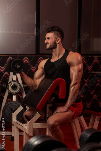 Muscular Man Exercising Biceps With Dumbbells