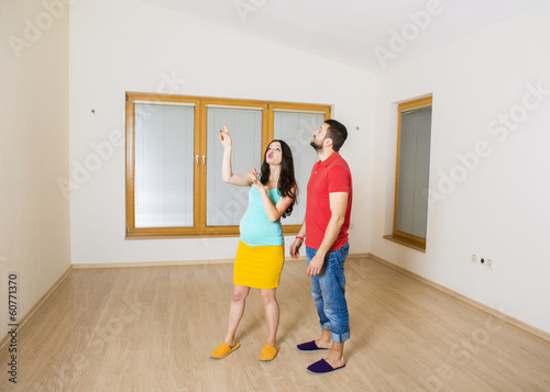 Pregnant mother and happy father in new house