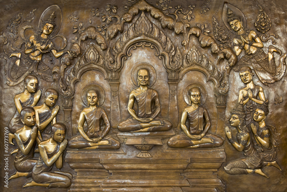 Buddha life scenes on carved metal at the temple in Thailand.