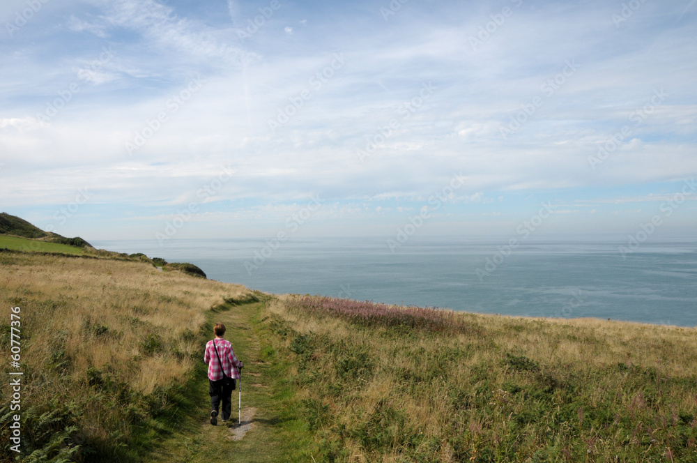 Walker on coastal path above Cardigan Bay