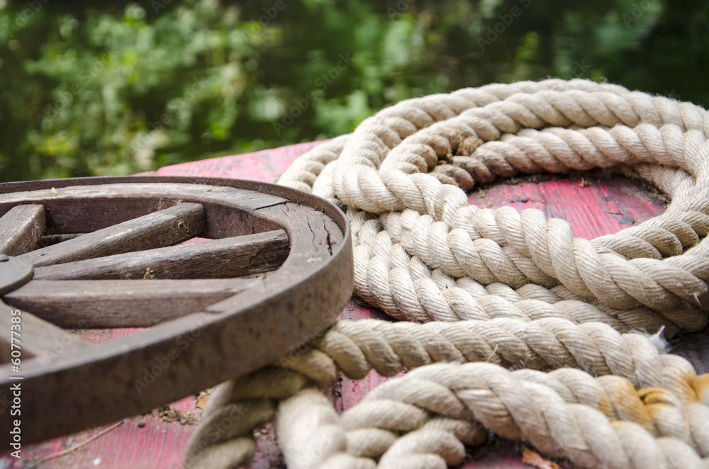 Fototapeta premium Old rolled ropes and a rusty wheel