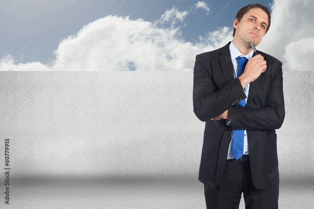 Composite image of thinking businessman holding pen Composite image of thinking businessman holding pen