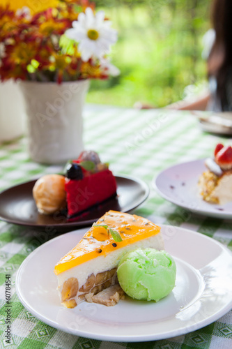Cheese cake and ice-cream on plate with fruit topping.