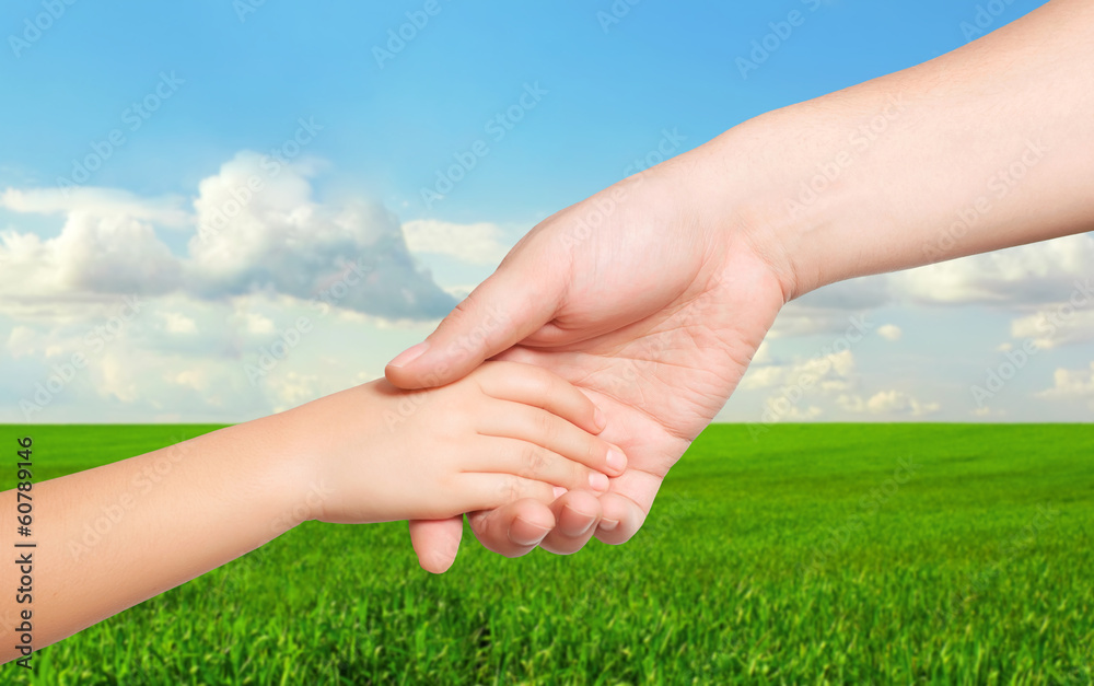 man hand and a child hand holding each other on the background man hand and a child hand holding each other on the background