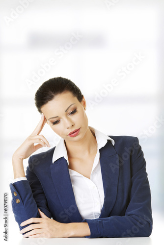 Sad businesswoman sitting behind the desk