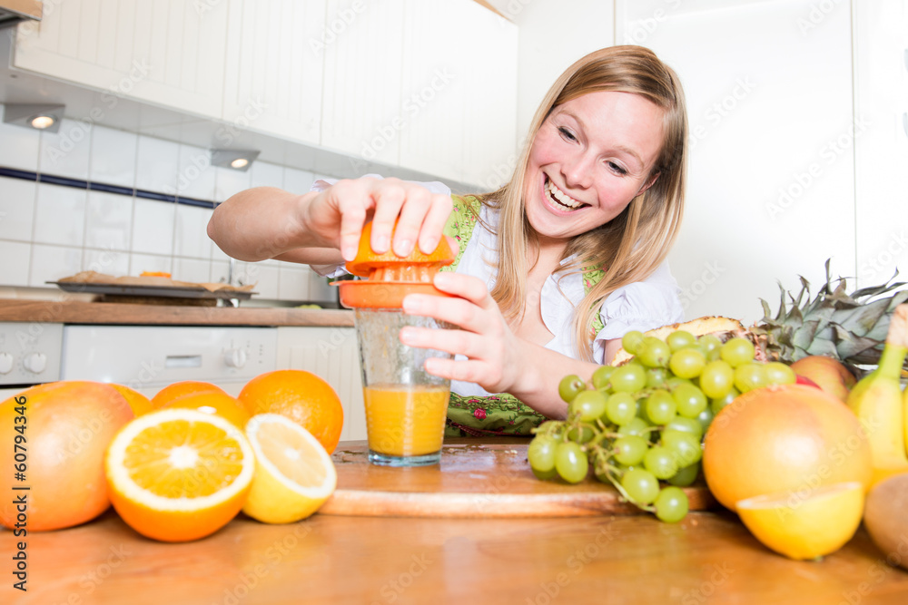 Junge Frau beim Saft pressen - Orangensaft Junge Frau beim Saft pressen - Orangensaft