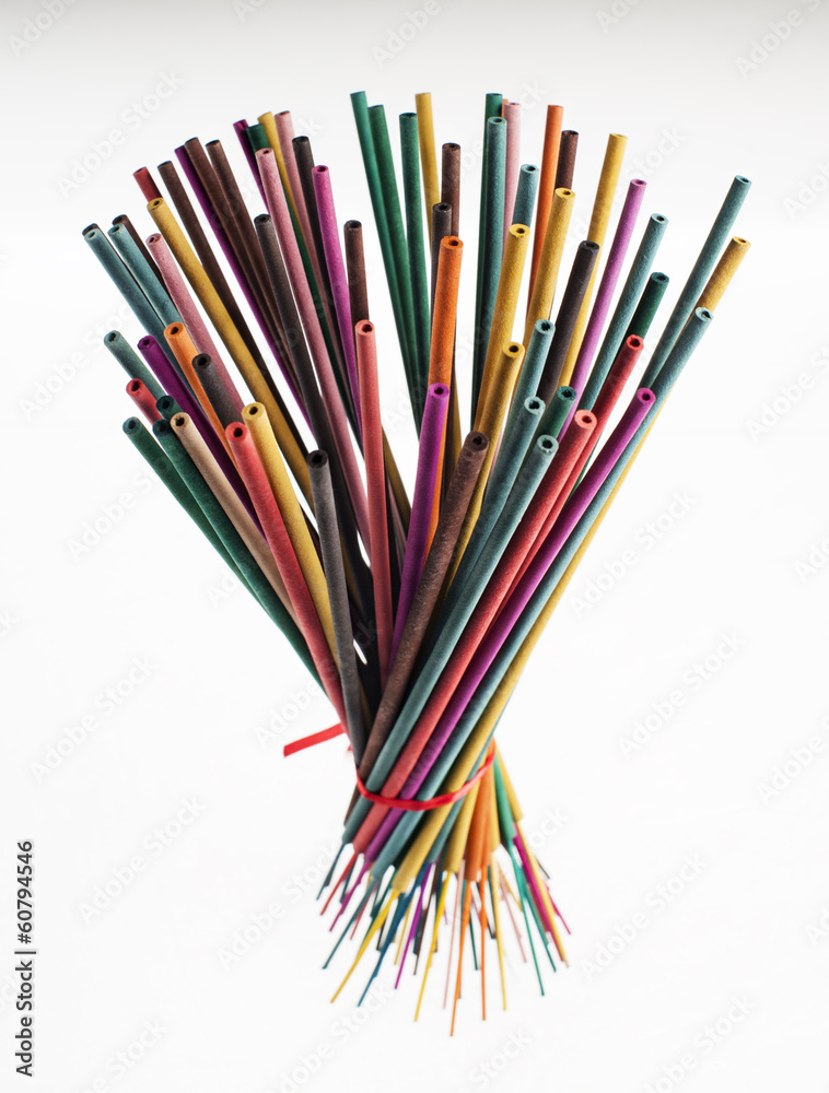 Creative group of colorful incense sticks on white background