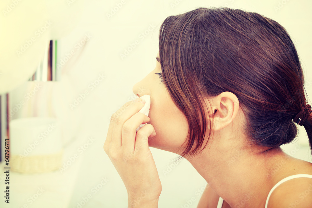 Young beautiful caucasian woman cleaning her face Young beautiful caucasian woman cleaning her face
