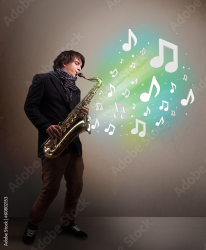 Young musician playing on saxophone while musical notes explodin photo