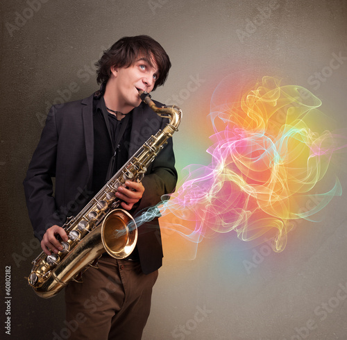 Attractive musician playing on saxophone with colorful abstract