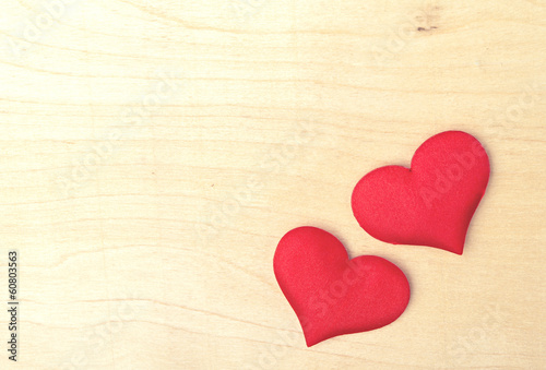 two red hearts on a wooden  board