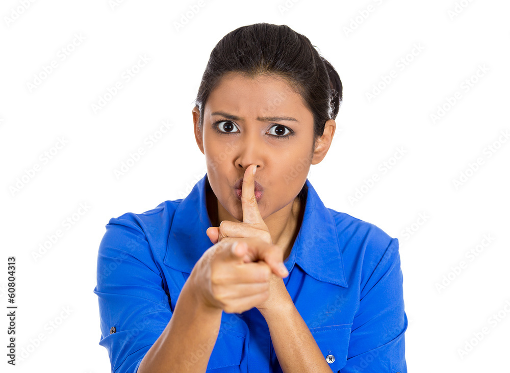 Woman placing finger on lips, pointing at you as if to say quiet Woman placing finger on lips, pointing at you as if to say quiet