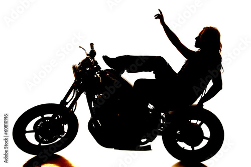 Fototapeta Naklejka Na Ścianę i Meble -  Silhouette woman on motorcycle pointing up