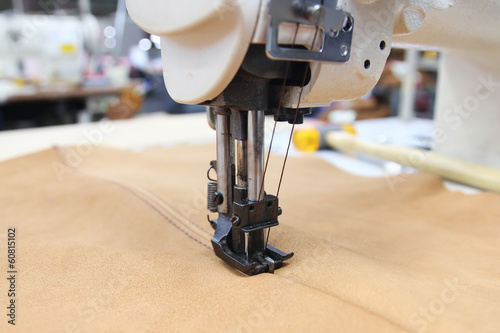 Closeup of sewing machine working part with leather
