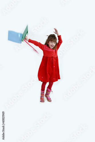Happy girl in red flying and jumping with colorful shopping bags photo