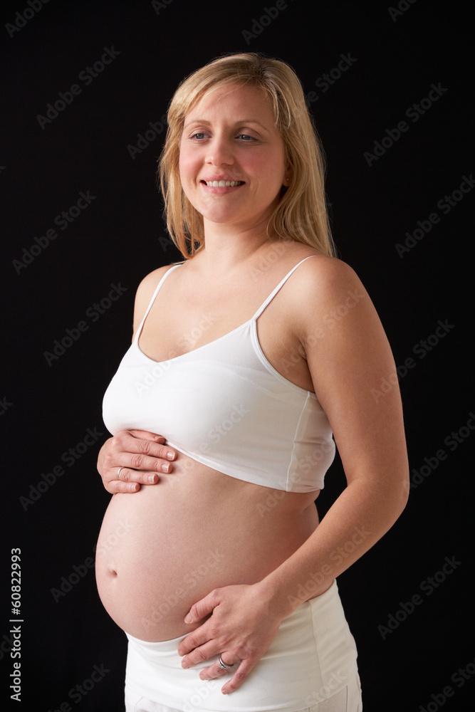 Portrait Of 5 months Pregnant Woman Wearing White On Black Backg Portrait Of 5 months Pregnant Woman Wearing White On Black Backg