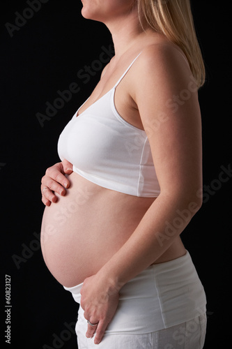 Close Up Portrait Of 5 months Pregnant Woman On Black Background photo