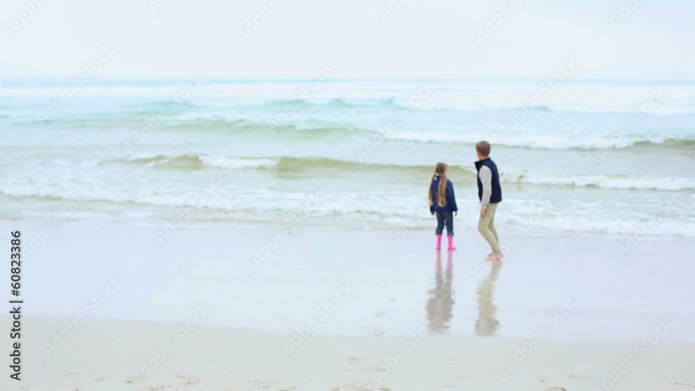 Siblings running towards the sea on the beach Siblings running towards the sea on the beach