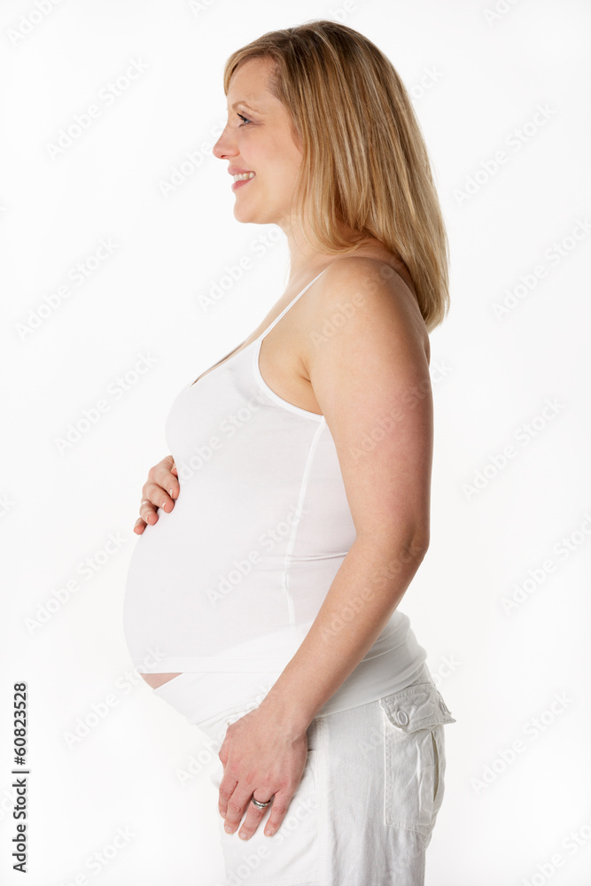 Studio Portrait Of 6 months Pregnant Woman Wearing White Studio Portrait Of 6 months Pregnant Woman Wearing White