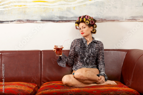 sexy girl drinking a drink on the couch photo