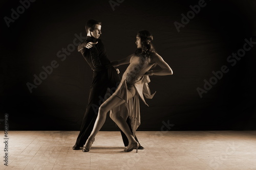 dancers in ballroom against on black background