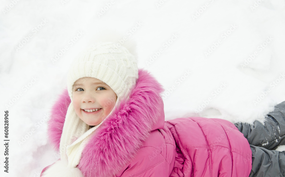 Smiling little girl lying in snow Smiling little girl lying in snow